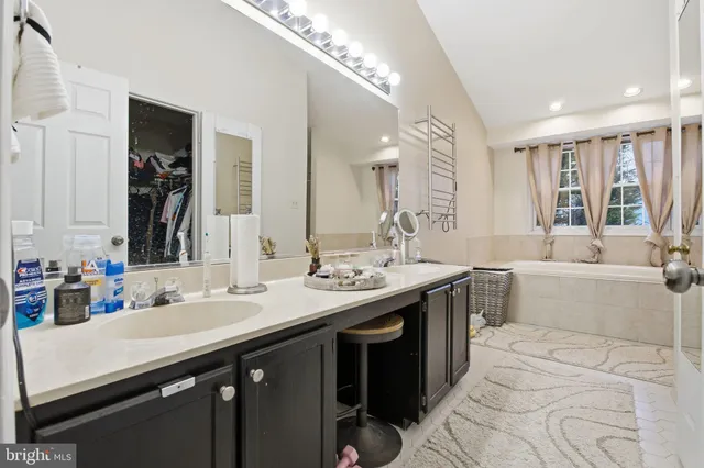a bathroom with a sink double vanity granite and a bathtub