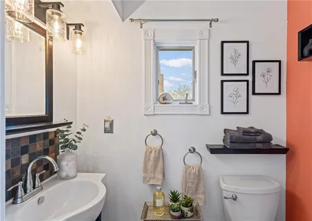a bathroom with a sink toilet and mirror