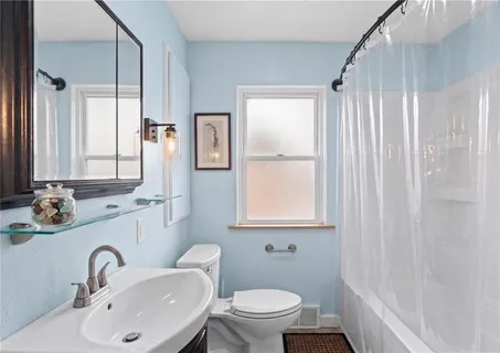 a bathroom with a sink toilet a mirror and shower