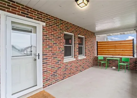 a view of a porch with furniture and floor to ceiling window