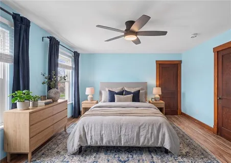 a bedroom with a bed chandelier and a window
