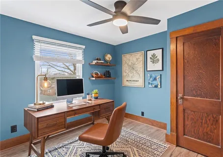 a view of a workspace with furniture and a window