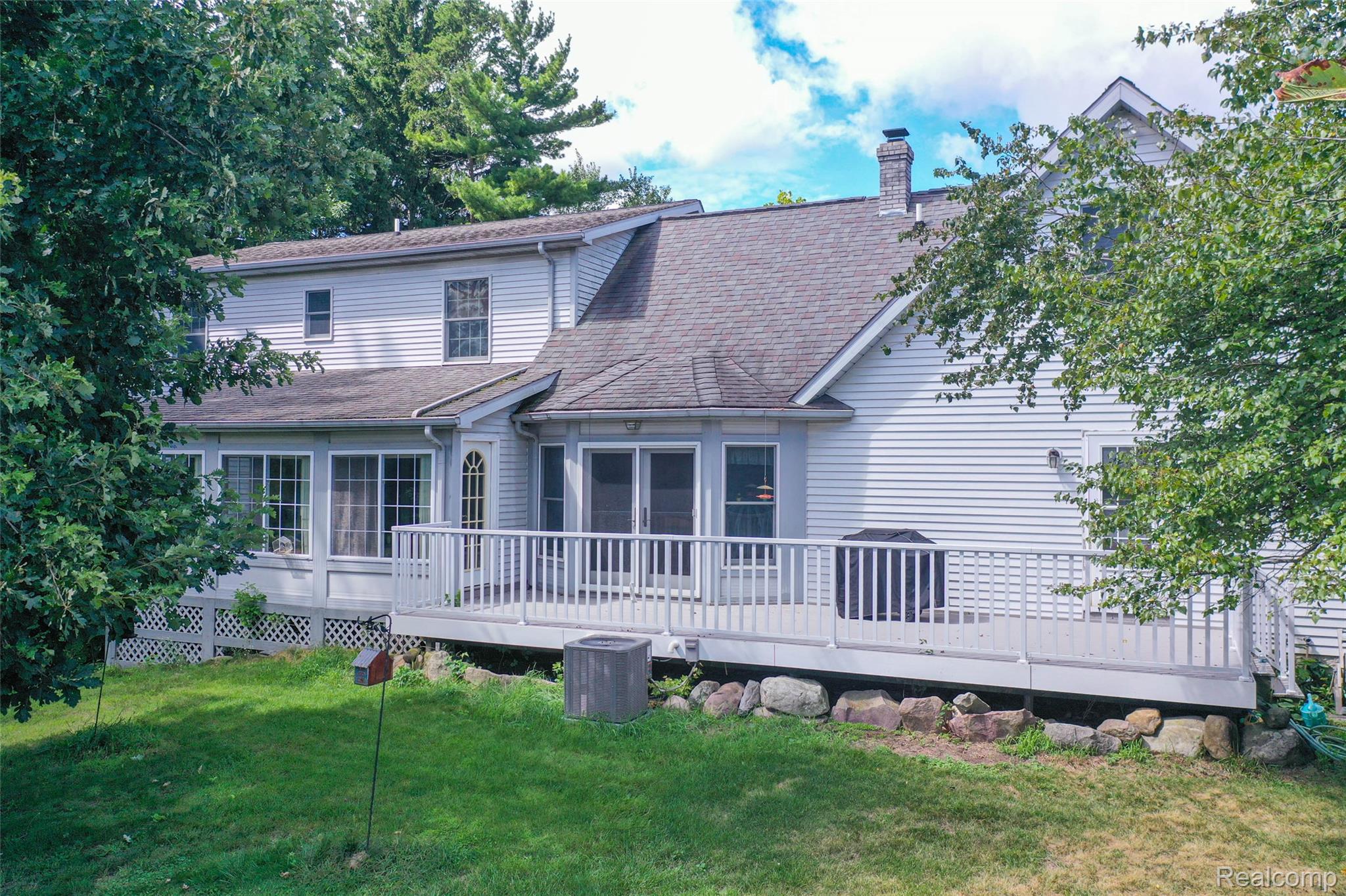 1591 Baldwin Road Lapeer, MI 48446 - Photo 35 of 46 Rear view of property featuring a wooden deck, a lawn, a shingled roof, and a chimney