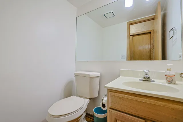 a bathroom with a toilet a sink and mirror