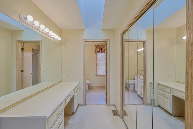 a spacious bathroom with a double vanity sink a toilet and shower