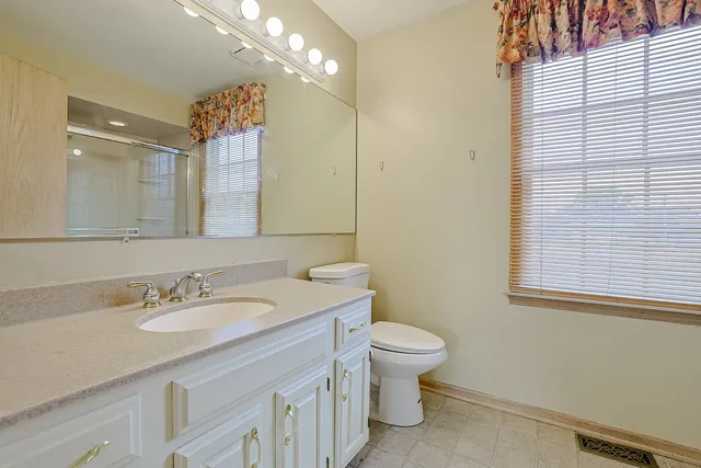 a bathroom with a sink a toilet and a mirror