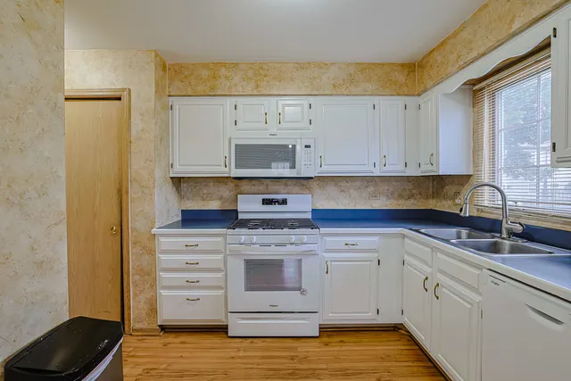a kitchen with stainless steel appliances granite countertop a sink and cabinets with wooden floor