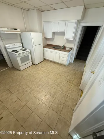 a kitchen with a sink a stove and cabinets
