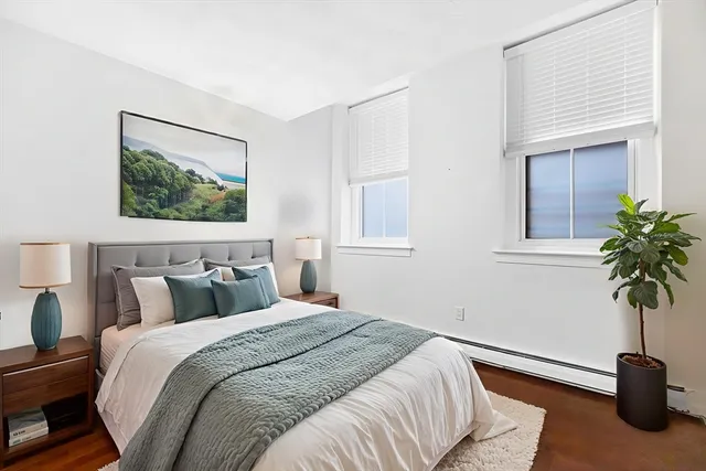 a bedroom with a bed and a potted plant