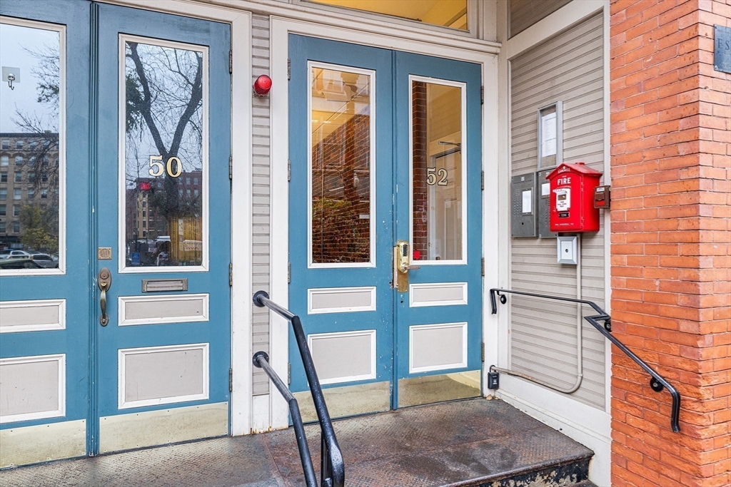 52-58 Washington Street, Unit BC Haverhill, MA 01832 - Photo 18 of 23 a view of a brick house with a red door and a window