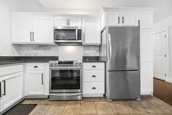 a kitchen with stainless steel appliances a refrigerator stove and microwave