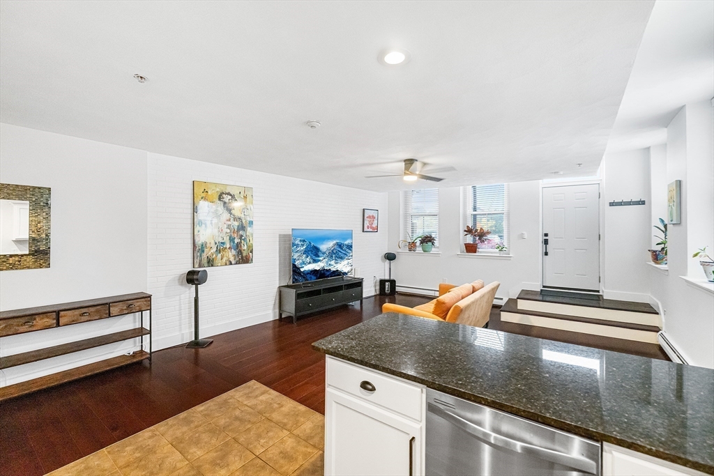 52-58 Washington Street, Unit BC Haverhill, MA 01832 - Photo 5 of 23 a kitchen with stainless steel appliances granite countertop a stove and white cabinets with wooden floor