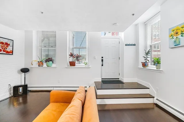 a living room with furniture and a potted plant