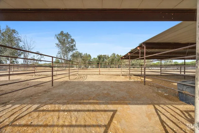 a backyard of a house with table and chairs under an umbrella