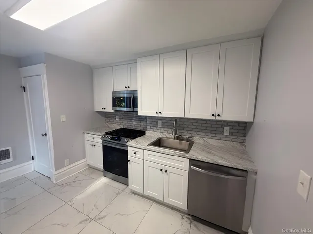 a kitchen with cabinets appliances and a sink