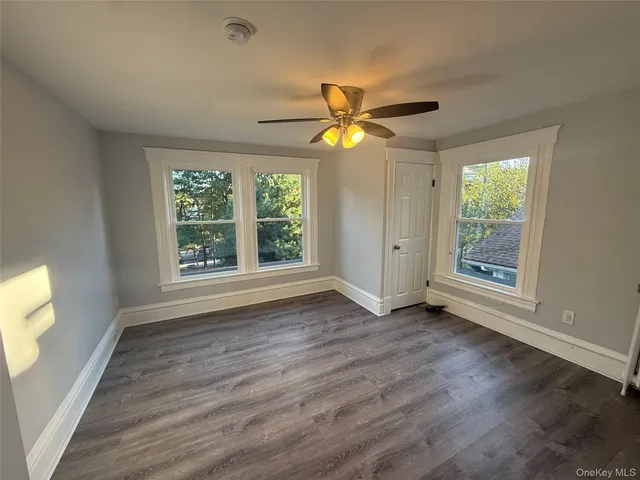 a view of room with window ceiling fan and hardwood floor