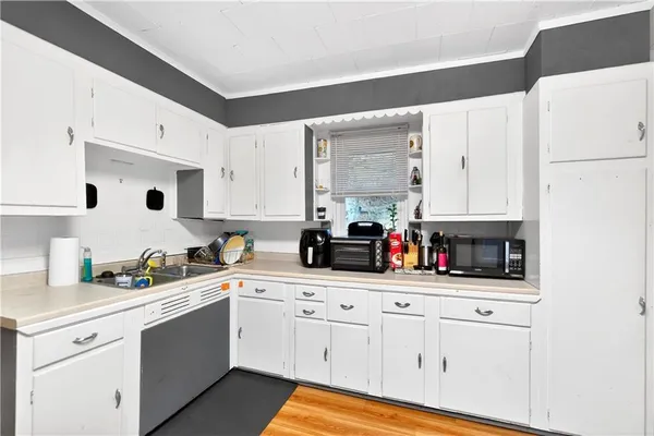 a kitchen with white cabinets and white appliances