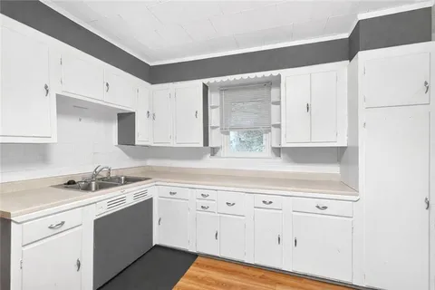 a large white kitchen with stainless steel appliances granite countertop a stove and a refrigerator