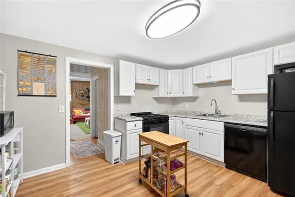 a kitchen with stainless steel appliances granite countertop a stove a sink dishwasher and a refrigerator with wooden floor