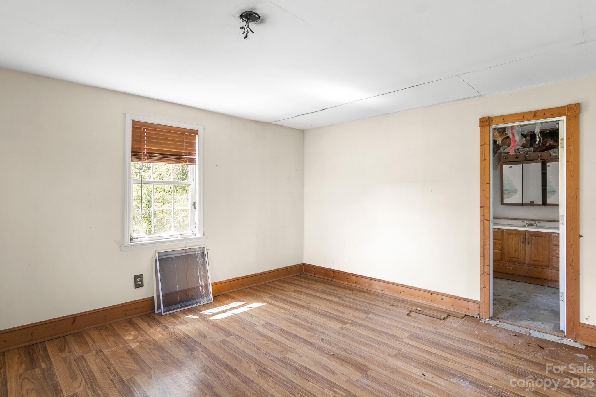 716 Robin Avenue Kannapolis, NC 28081 - Photo 22 of 25 an empty room with wooden floor and windows