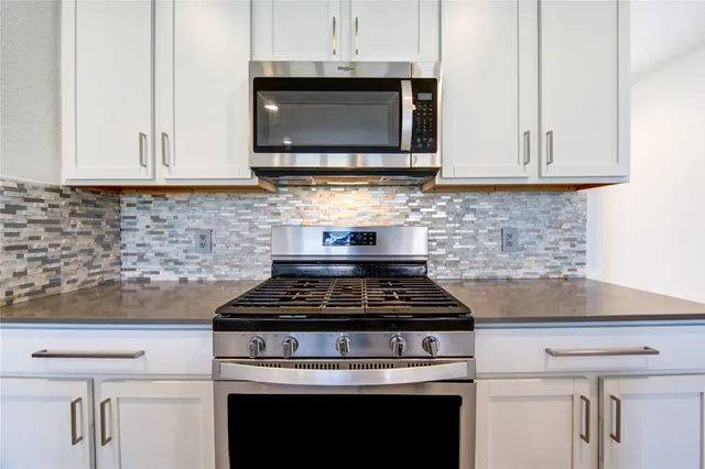 a kitchen with stainless steel appliances a stove sink and microwave