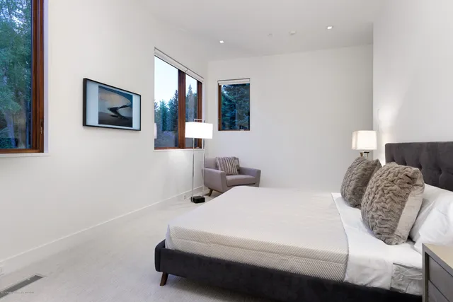 a bedroom with a white bed and a flat screen tv