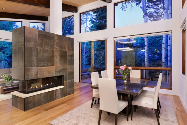 a dining room with furniture a fireplace and wooden floor