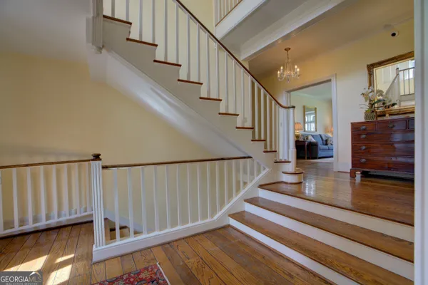 a living room with furniture hard wood floor and a ceiling fan