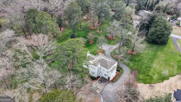 an aerial view of a house with a yard and lake view