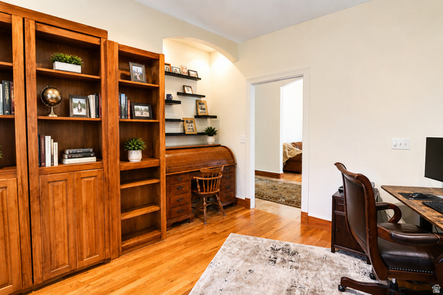 1055 North 1000 East Mapleton, UT 84664 - Photo 8 of 112 Hardwood flooring throughout featuring built-in wood cabinetry, integrated shelving, and an arched doorway