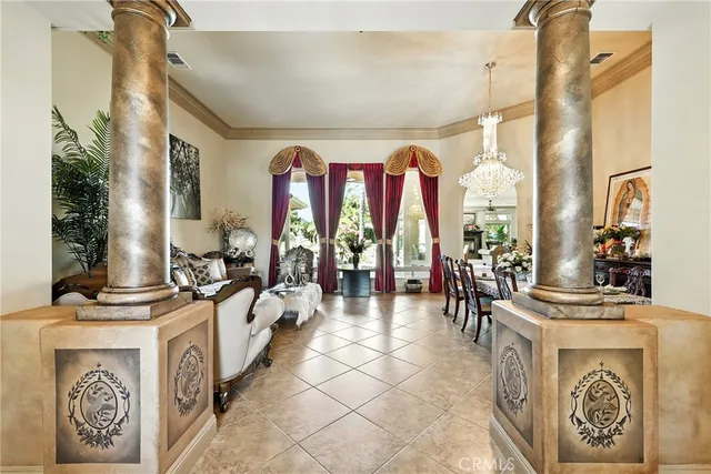 a living room with furniture a chandelier and a large mirror