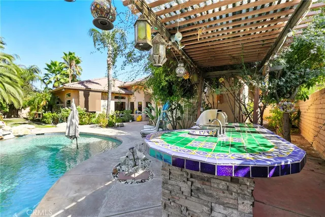 a backyard of a house with table and chairs under an umbrella
