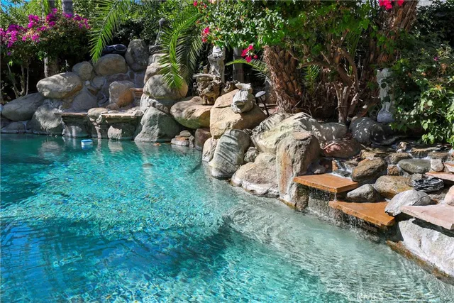 a view of a house with a yard and palm trees