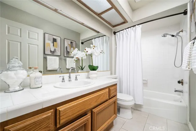a bathroom with a granite countertop sink a toilet and shower