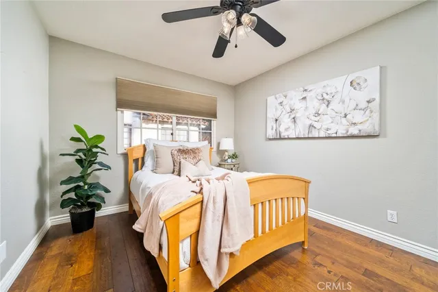 a bed sitting in a bedroom next to a window with potted plant
