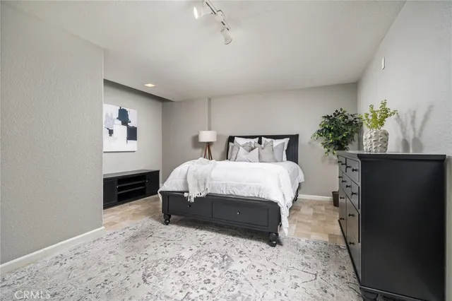 a spacious bedroom with a bed and a potted plant