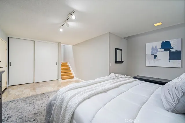 a bedroom with a large bed and a chandelier