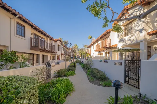 a front view of a house with garden and plants