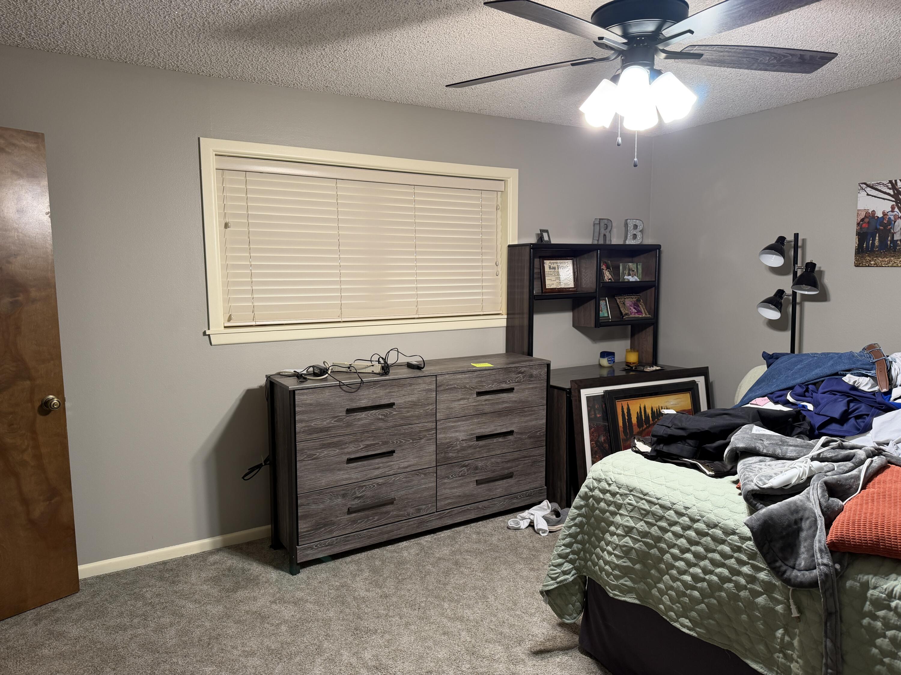 1603 South 8th Street Lamesa, TX 79331 - Photo 14 of 39 a bedroom with a bed and a chandelier