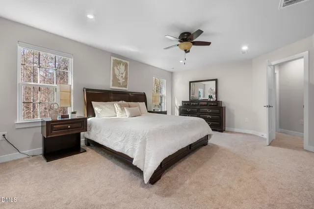 a bedroom with a large bed and a chandelier