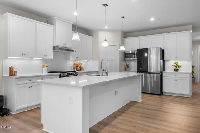 a kitchen with refrigerator cabinets and wooden floor