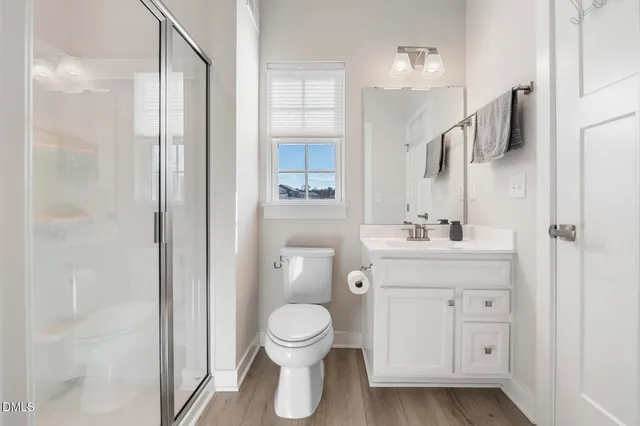 a bathroom with a toilet sink a shower and mirror