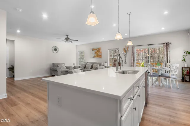 a large kitchen with kitchen island a island a sink a stove and a wooden floors