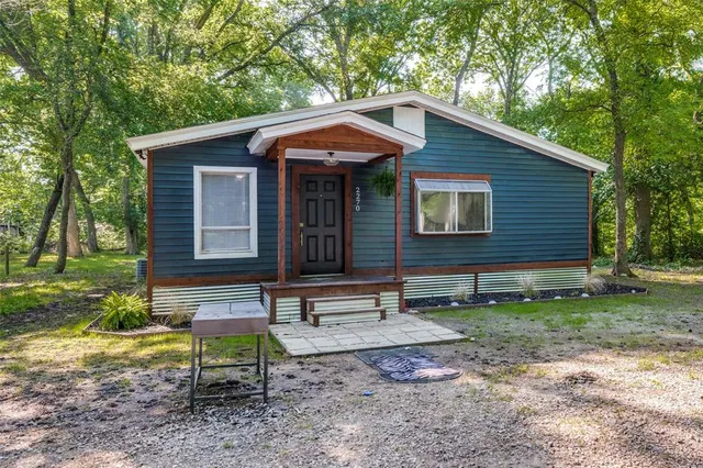 a view of a house with a yard chairs and a fire pit