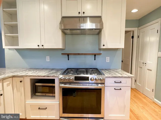 a stove top oven sitting inside of a kitchen