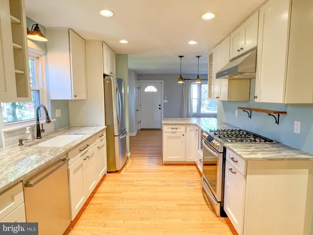 a kitchen with a stove a sink a refrigerator and a microwave