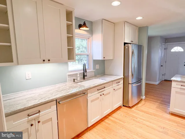 a kitchen with stainless steel appliances granite countertop a refrigerator sink and cabinets