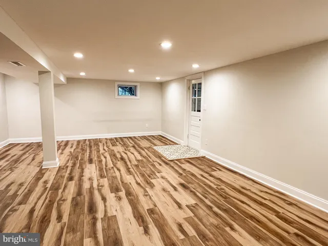 a view of empty room with wooden floor