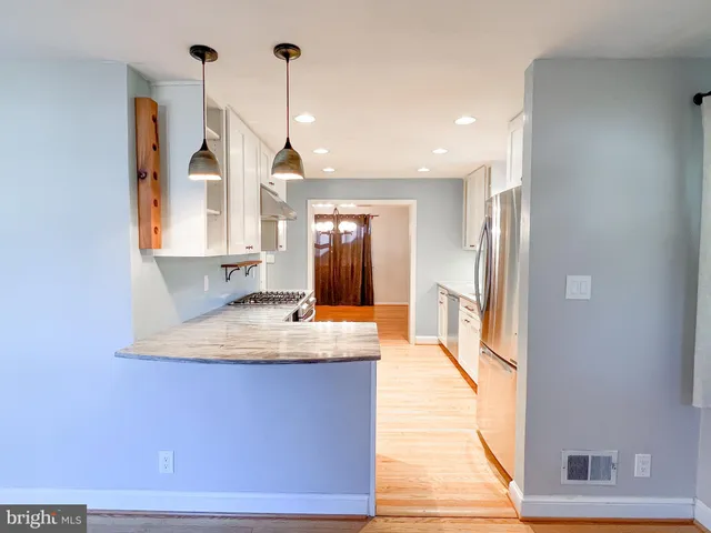 a view of a kitchen with kitchen island a sink wooden floor and a window
