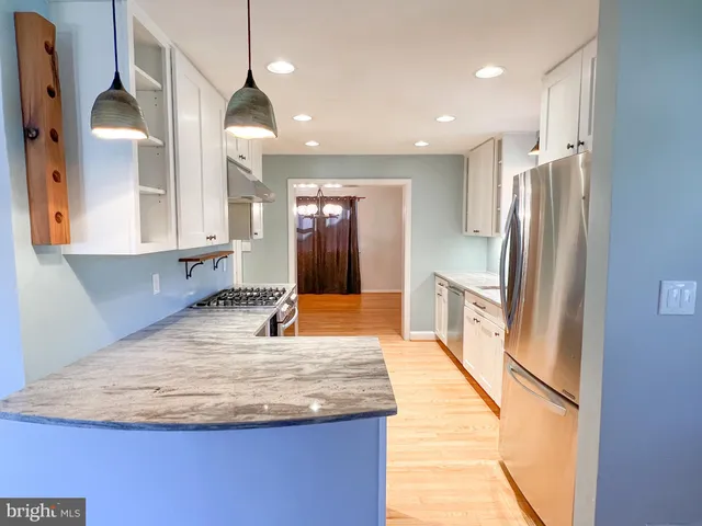 a kitchen with stainless steel appliances granite countertop a refrigerator a sink and a stove